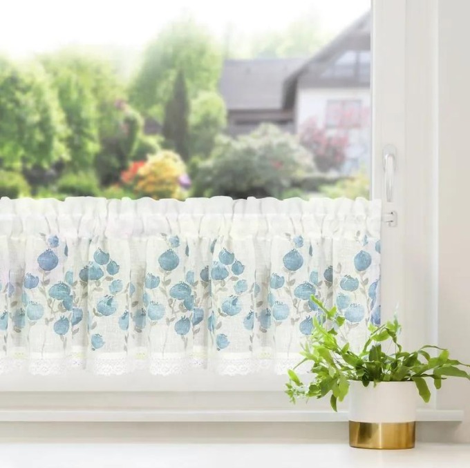 Bílá záclona na pásce s potiskem modrých květů dodá vaší kuchyni domácký a útulný charakter